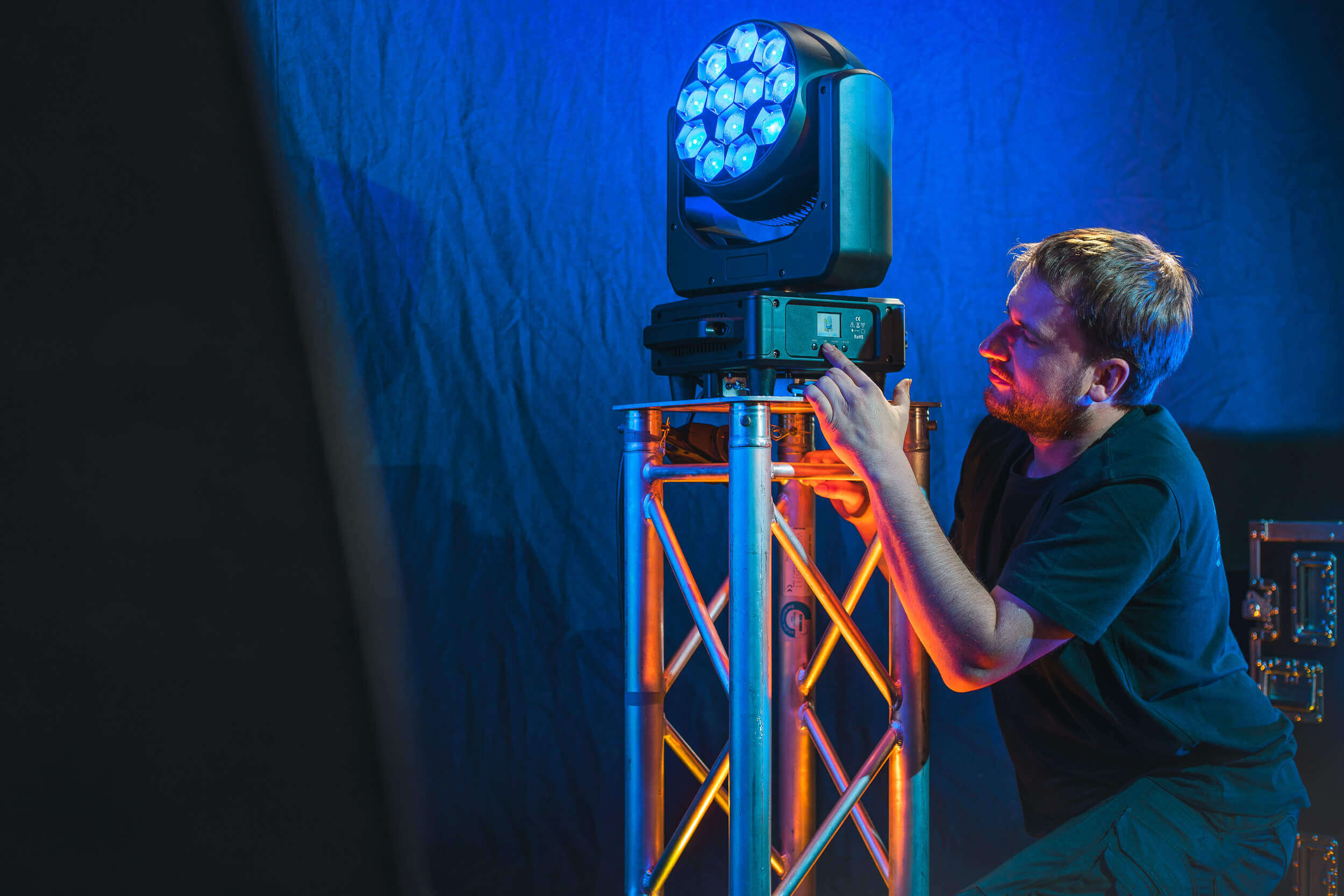 Ein Mann installiert Strahler an einer Traverse